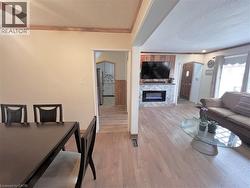 Living area featuring wood-finish flooring and a fireplace with a stone-finish surround - 
