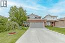 Traditional-style house featuring concrete driveway, a front yard, brick siding, and an attached garage - 32 Vineberg Drive, Hamilton, ON  - Outdoor With Facade 