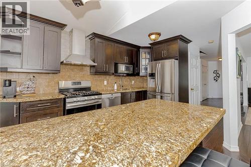 Kitchen with stainless steel appliances, decorative backsplash, open shelves, dark wood-style floors, and dark wood finish cabinetry - 32 Vineberg Drive, Hamilton, ON - Indoor Photo Showing Kitchen With Upgraded Kitchen