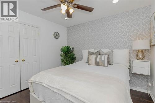 Bedroom featuring wallpapered walls, an accent wall, ceiling fan, dark wood-type flooring, and a closet - 32 Vineberg Drive, Hamilton, ON - Indoor Photo Showing Bedroom