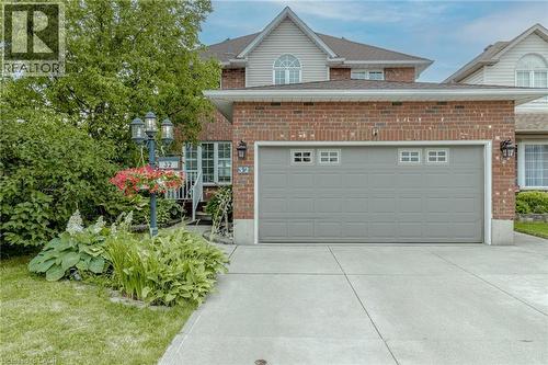 View of front of property featuring brick siding, concrete driveway, and an attached garage - 32 Vineberg Drive, Hamilton, ON - Outdoor