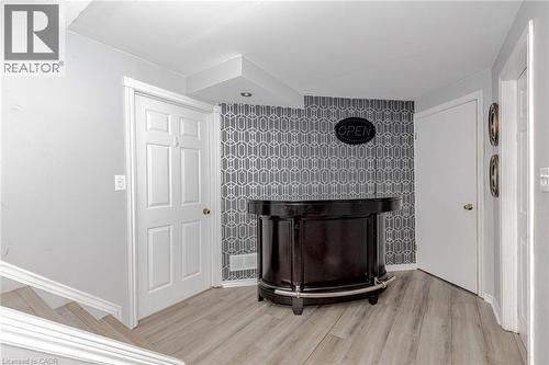Detailed view of wood finished floors and an accent wall - 32 Vineberg Drive, Hamilton, ON - Indoor Photo Showing Other Room