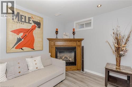 Living area with a glass covered fireplace and light wood-style floors - 32 Vineberg Drive, Hamilton, ON - Indoor Photo Showing Other Room With Fireplace