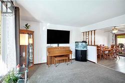 Carpeted living space with white walls and a large window for plenty of natural light - 