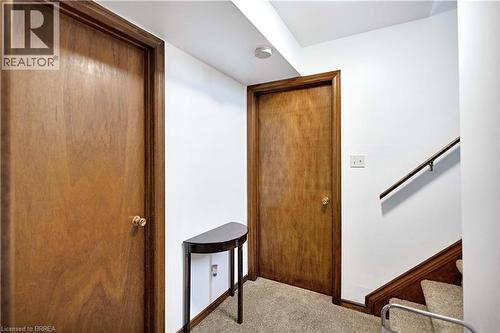 Interior hallway featuring two wood-finish doors, white walls, and carpeted flooring - 16 Sandlewood Avenue, Brantford, ON - Indoor Photo Showing Other Room