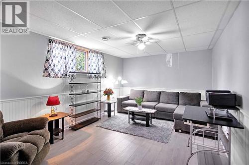 Finished room featuring light wood-finish flooring, white wainscoting, and a drop ceiling with recessed lighting and a ceiling fan - 16 Sandlewood Avenue, Brantford, ON - Indoor Photo Showing Other Room