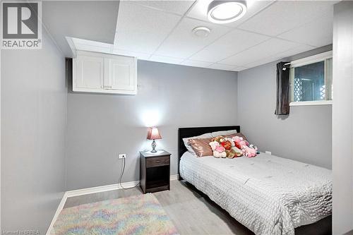 Light gray painted walls and wood-finish flooring define this room - 16 Sandlewood Avenue, Brantford, ON - Indoor Photo Showing Bedroom