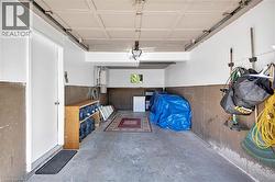 Attached garage featuring a white door, concrete flooring, and a textured ceiling - 