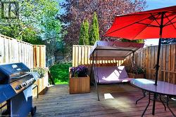 Expansive wood deck with a privacy fence, integrated planter boxes, and a lush lawn beyond - 