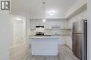 Kitchen with stainless steel appliances, under cabinet range hood, light wood-type flooring, and a sink - 25 Isherwood Avenue Unit# G-105, Cambridge, ON  - Indoor Photo Showing Kitchen With Stainless Steel Kitchen With Upgraded Kitchen 