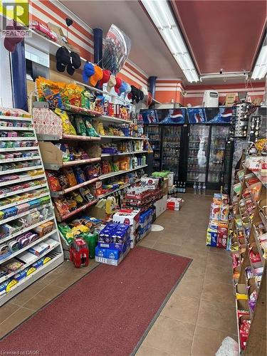 Retail space with tiled flooring and ample display shelving - 1 King Street E, Hamilton, ON 