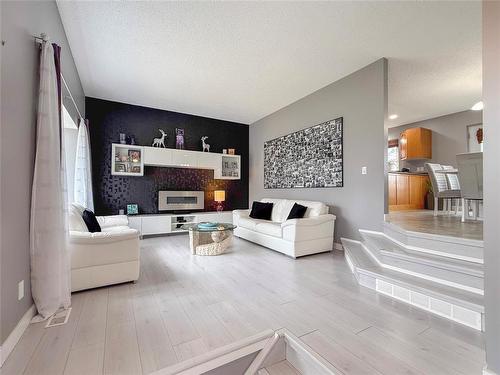 TV Console & Cabinet included - 12 Dominion Way, Brandon, MB - Indoor Photo Showing Living Room With Fireplace