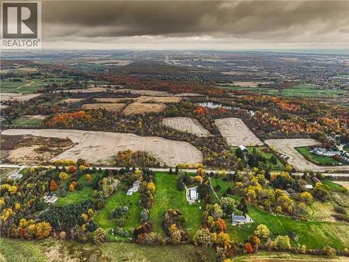 Aerial landscape featuring expansive fields, dense tree lines with autumnal foliage, and scattered residential properties - 3415 Cedar Springs Road, Burlington, ON 