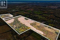 Expansive land parcel featuring a mix of open fields and mature woodland - 