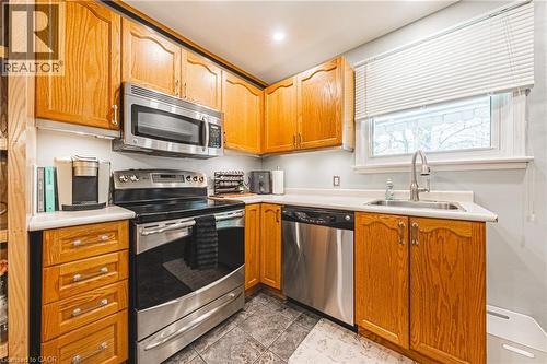 Kitchen featuring wood cabinetry, stainless steel appliances, and laminate countertops - 242 East 43Rd Street, Hamilton, ON - Indoor Photo Showing Kitchen
