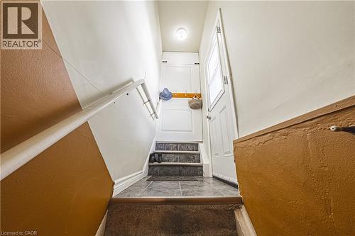 Stairwell featuring a two-toned wall finish, a white handrail, and a practical coat rack - 242 East 43Rd Street, Hamilton, ON - Indoor Photo Showing Other Room