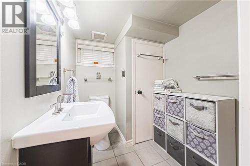 Bathroom featuring a modern vanity with integrated sink, a large wall-mounted mirror, and tile flooring - 242 East 43Rd Street, Hamilton, ON - Indoor Photo Showing Bathroom