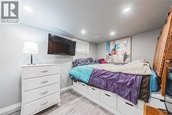 Bedroom featuring wood-finish flooring, recessed lighting, and a window with blinds - 