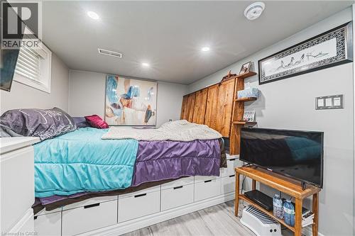 Room featuring recessed lighting, a built-in bed frame with integrated storage drawers, wood-finish flooring, a small window with blinds, and a permanent wooden shelving unit - 242 East 43Rd Street, Hamilton, ON - Indoor Photo Showing Bedroom