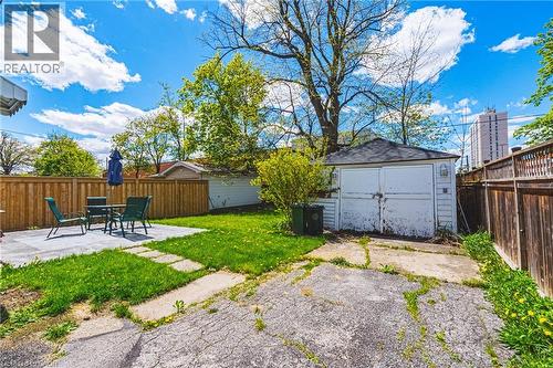 Expansive backyard featuring a concrete patio, a detached garage, and wood privacy fencing - 242 East 43Rd Street, Hamilton, ON - Outdoor
