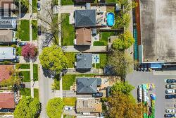 Aerial perspective showcasing a residential street with detached homes and green spaces - 