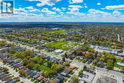 Expansive aerial view showcasing a residential neighborhood with numerous homes and mature trees - 