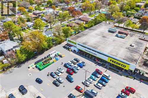 Aerial perspective showcasing a commercial building with a retail storefront, large parking area, and surrounding residential properties - 242 East 43Rd Street, Hamilton, ON -  With View