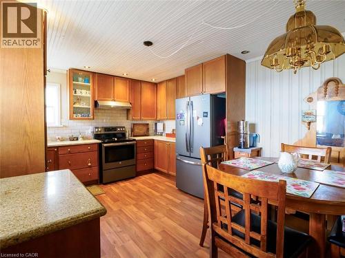 Kitchen to the left upon entering features wood cabinetry, stainless steel appliances, white subway tile backsplash - 1395 Lakeshore Road, Haldimand County, ON - Indoor