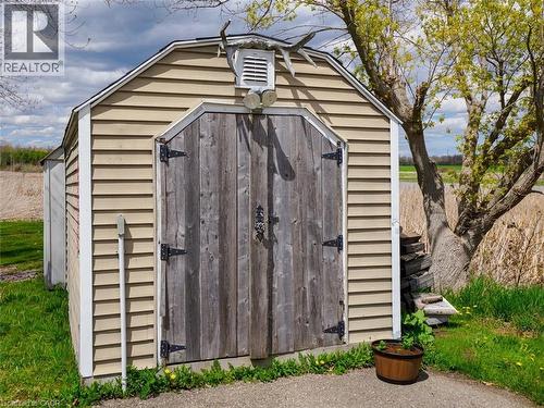 Outdoor storage shed featuring horizontal tan siding and a gambrel roof - 1395 Lakeshore Road, Haldimand County, ON - Outdoor