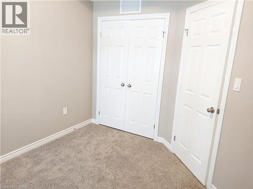 Wall-to-wall carpeting with light beige walls and white trim - 26 Wheat Lane, Kitchener, ON - Indoor Photo Showing Other Room