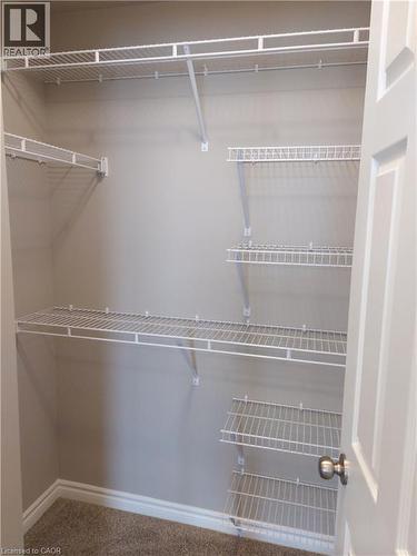 Walk-in closet featuring built-in wire shelving, white trim, and neutral-toned wall paint - 26 Wheat Lane, Kitchener, ON - Indoor With Storage