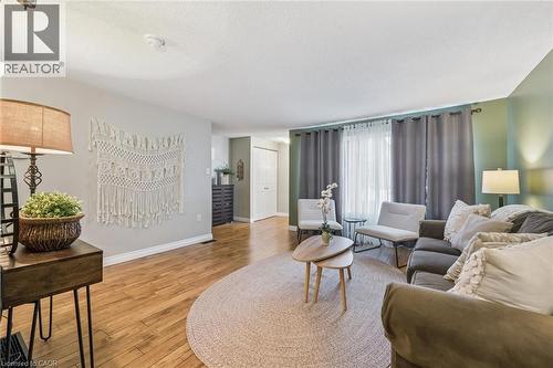 Wood-finish flooring throughout, light-colored walls, and windows with curtain rods - 460 Parkview Crescent, Cambridge, ON - Indoor Photo Showing Living Room