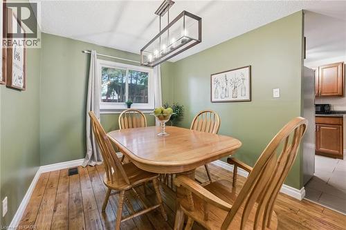 Wood-finish flooring with a rectangular window, white trim, and a linear pendant light fixture - 460 Parkview Crescent, Cambridge, ON - Indoor Photo Showing Dining Room