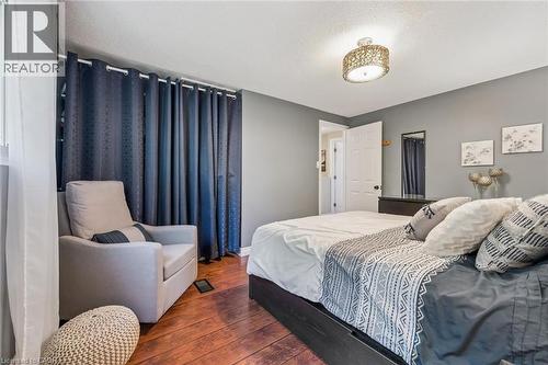 Hardwood-style flooring, white trim details, and a decorative ceiling light fixture - 460 Parkview Crescent, Cambridge, ON - Indoor Photo Showing Bedroom