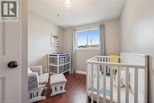 Wood-finish flooring with a neutral wall color, white trim, and a window with curtains - 460 Parkview Crescent, Cambridge, ON - Indoor Photo Showing Bedroom