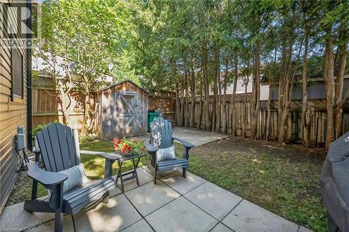 Paved patio area, mature trees, wooden privacy fencing, wooden storage shed, and a grassed yard - 460 Parkview Crescent, Cambridge, ON - Outdoor
