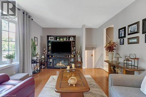 Hardwood flooring throughout, built-in media console with fireplace, large window with ample natural light, neutral wall colors, and multi-level architectural features - 236 Winston Boulevard, Cambridge, ON - Indoor Photo Showing Living Room