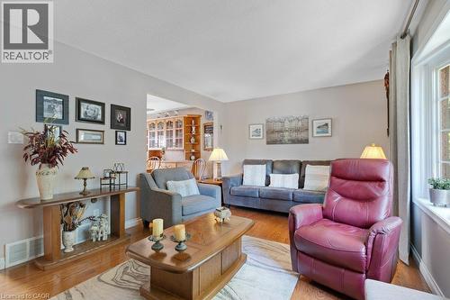 Hardwood-finish flooring throughout, light neutral wall paint, and a large bay window - 236 Winston Boulevard, Cambridge, ON - Indoor Photo Showing Living Room