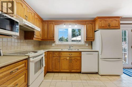 Wood-finish cabinetry, tile flooring, and a tile backsplash - 236 Winston Boulevard, Cambridge, ON - Indoor Photo Showing Kitchen With Double Sink
