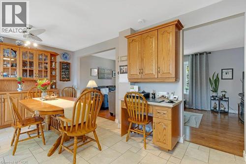 Tile flooring in the dining area with a built-in wooden hutch and glass-front cabinetry - 236 Winston Boulevard, Cambridge, ON - Indoor Photo Showing Dining Room