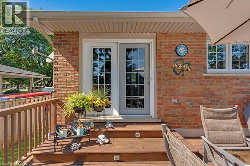 Brick exterior featuring a wooden deck with steps, a full-lite glass door, and a multi-pane window - 236 Winston Boulevard, Cambridge, ON - Outdoor With Deck Patio Veranda With Exterior