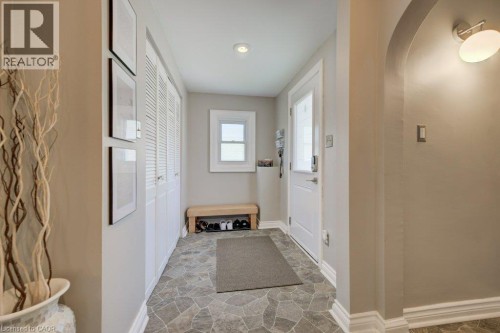 Entryway featuring stone-look flooring, a white paneled door with frosted glass insert, and a white louvered bifold closet - 209 Belleview Avenue, Kitchener, ON - Indoor Photo Showing Other Room