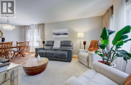 Living and dining areas featuring wood-finish flooring, recessed lighting, and large windows with sheer curtains - 209 Belleview Avenue, Kitchener, ON - Indoor Photo Showing Living Room