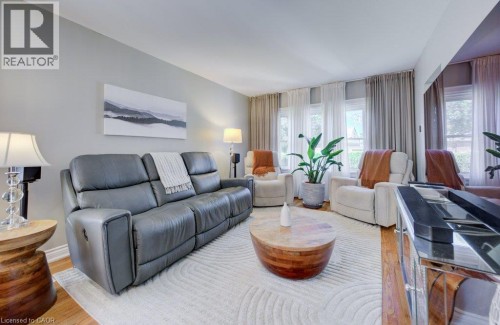 Hardwood flooring complements light-toned walls and trim, with multiple windows providing natural illumination - 209 Belleview Avenue, Kitchener, ON - Indoor Photo Showing Living Room