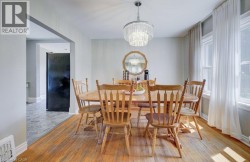 Dining area featuring wood-finish flooring and a tiered crystal chandelier - 