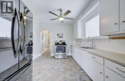 Bright kitchen featuring extensive white cabinetry, coordinating countertops, and a stainless steel appliance suite - 