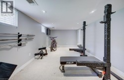 Recessed lighting illuminates the carpeted floor and light grey walls - 