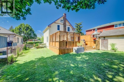 Expansive backyard with a manicured lawn, multi-level wooden deck with privacy screening, and a detached storage shed - 209 Belleview Avenue, Kitchener, ON - Outdoor With Deck Patio Veranda