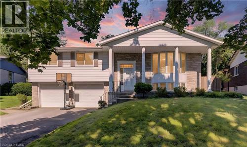 Split-level residence featuring a stone and siding exterior, a covered front entry with columns, a prominent bay window, and an attached two-car garage - 106 Autumn Hill Crescent, Kitchener, ON - Outdoor