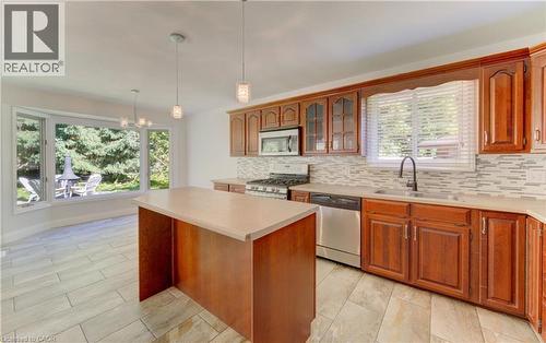 Kitchen featuring wood cabinetry, stainless steel appliances, a center island with countertop, and tile flooring - 106 Autumn Hill Crescent, Kitchener, ON - Indoor Photo Showing Kitchen With Double Sink